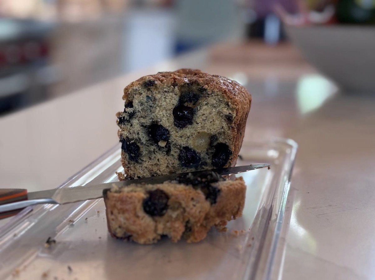 A sliced loaf of blueberry banana bread studded with juicy blueberries, ready to enjoy.